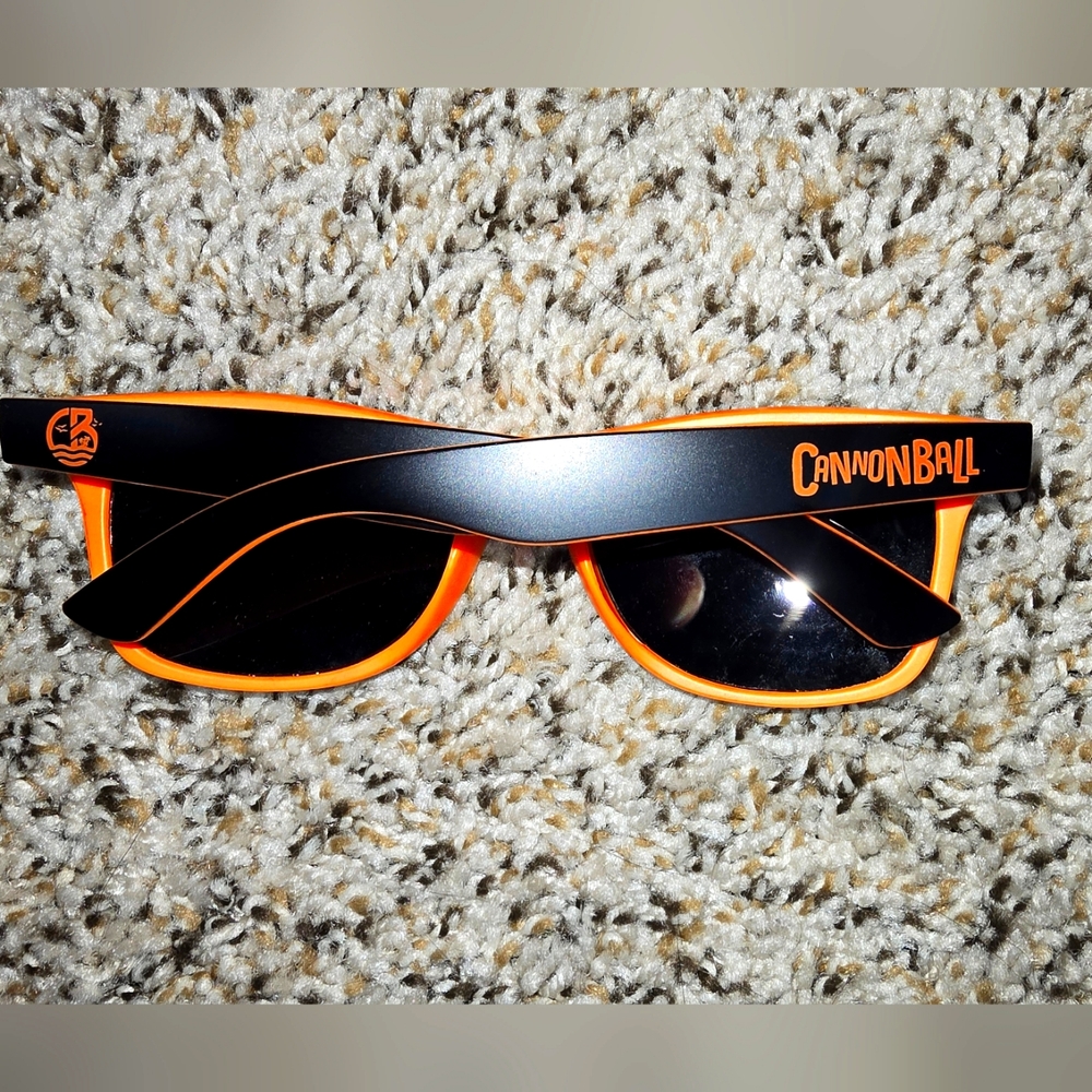 Orange sunglasses that say Cannonball on them